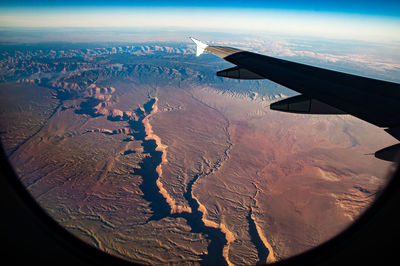 Cropped image of airplane wing over sea