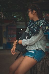 Woman looking away while sitting outdoors