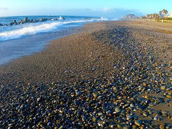 Pebbles on beach against sky