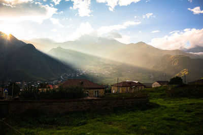 Scenic view of houses and mountains against sky