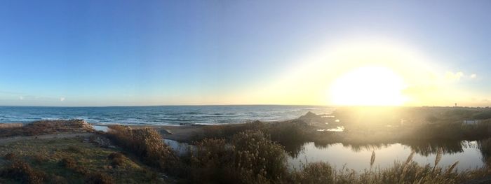 Scenic view of sea against bright sun