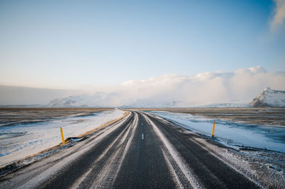 Empty road against sky during winter