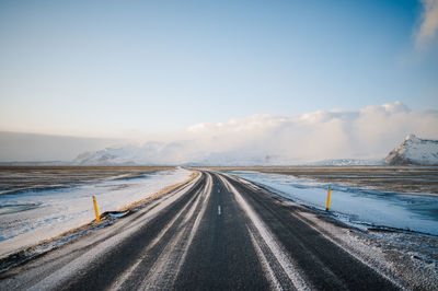 Empty road against sky during winter