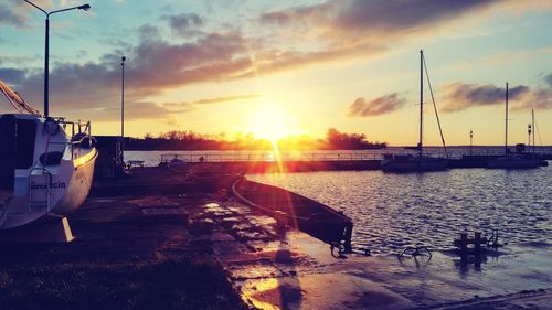 Boats moored in marina at sunset