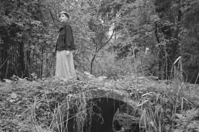 Woman standing by plants on field