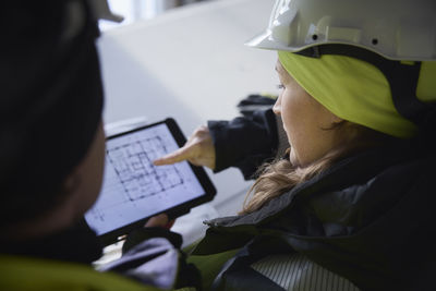 Engineers checking plans on digital tablet