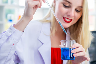 Midsection of scientist examining chemical in laboratory