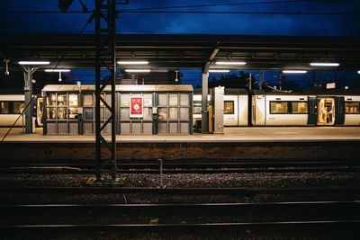 Train at railroad station platform at night