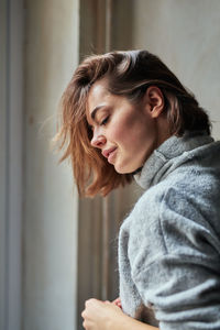 Side view of mature woman looking away at home