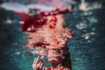 Low section of woman swimming in water