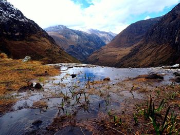 Scenic view of lake by mountains against sky