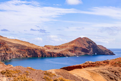 Scenic view of sea and mountains against sky