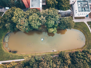 High angle view of dirty pond by buildings