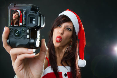 Portrait of beautiful woman holding camera