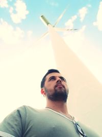 Low angle portrait of young man against sky