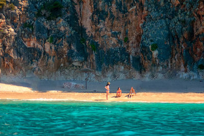 People enjoying in swimming pool against sea