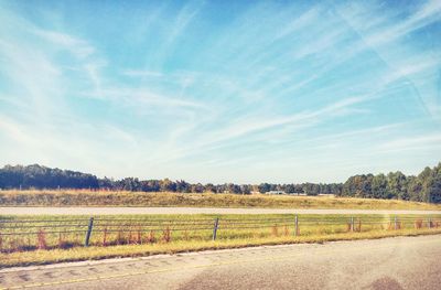 Scenic view of field against cloudy sky