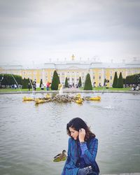 Woman standing by river against sky