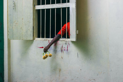 Midsection of man hanging on wall