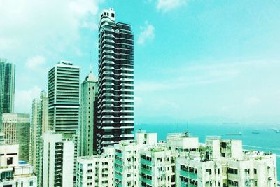 Buildings in city against cloudy sky