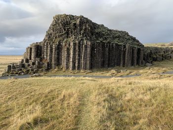 Old ruins on field against sky