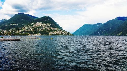 Scenic view of lake by mountains against sky