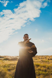 Side view of woman standing on field against sky