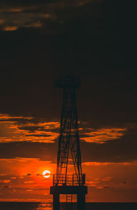 Silhouette tower against sky during sunset