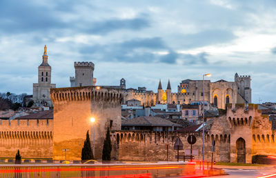 Buildings in city against cloudy sky