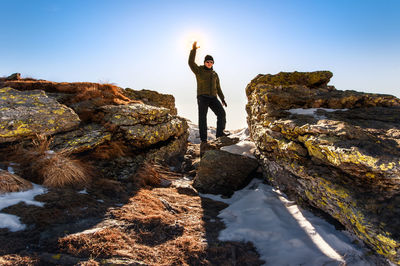 Man standing on snowcapped mountain against sky