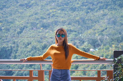 Portrait of woman standing against mountains