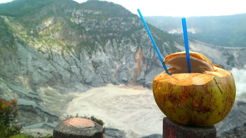 Close-up of pumpkin on rock against mountain