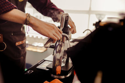 A barista pressing coffee in coffee shop