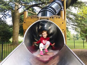 Low angle view of girl on slide at playground