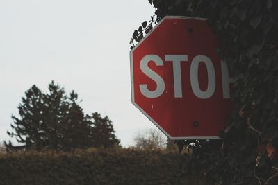 Close-up of road sign on field against sky