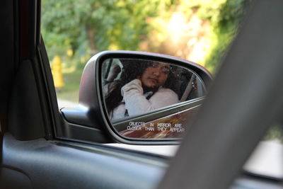 Reflection of woman in car mirror