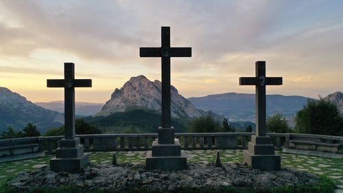 View of cross in mountains against sky