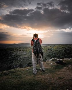 Full length of man photographing on landscape against sky