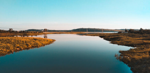 Scenic view of lake against clear blue sky