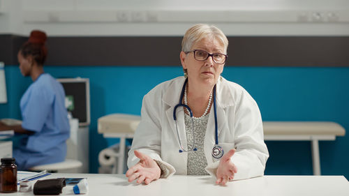 Portrait of doctor gesturing in clinic