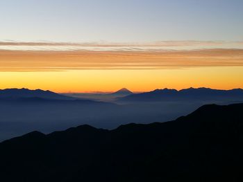 Scenic view of silhouette mountains against sky at sunset