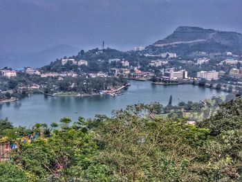 Scenic view of river by town against sky