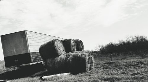 Hay bales on field against sky