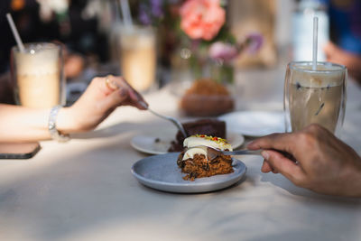 Midsection of woman having slice of cake