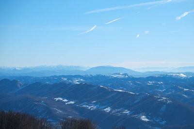 Aerial view of mountains against blue sky