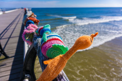 Close-up of multi colored umbrellas on beach against sky