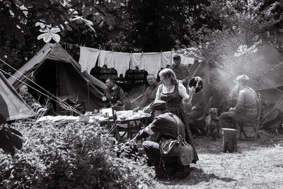 People sitting in tent on field