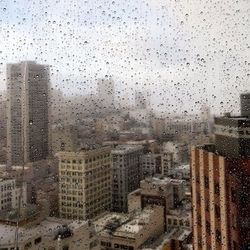 Cityscape seen through wet window during rainy season
