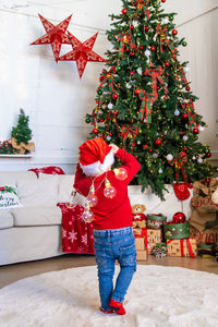Portrait of boy standing by christmas tree