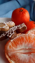 Close-up of orange fruits and cristmas cookies in plate